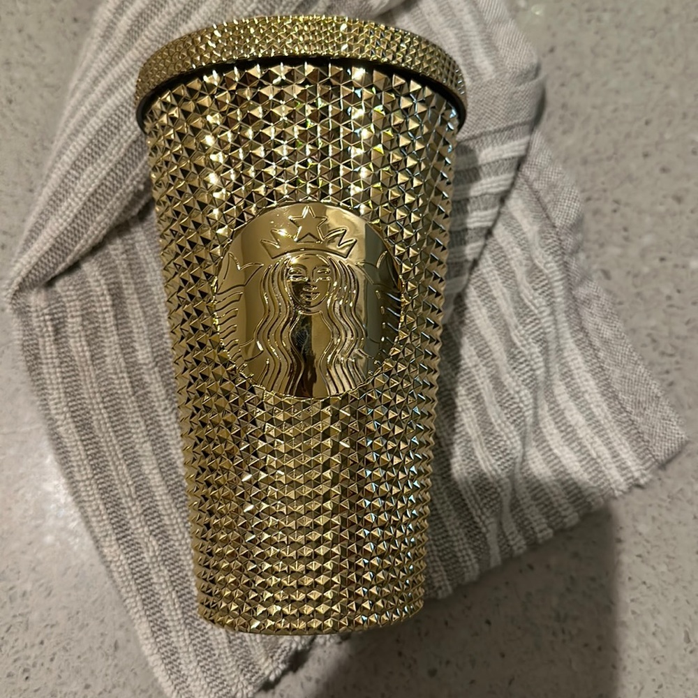 Gold grande size Starbucks cup with straw